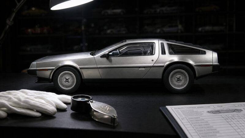 検品ライトの下に置かれたオートアートのデロリアン ミニカーと検品用手袋