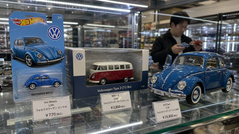 ホビーショップに並ぶフォルクスワーゲンのミニカーとスケール別価格帯を示す写真